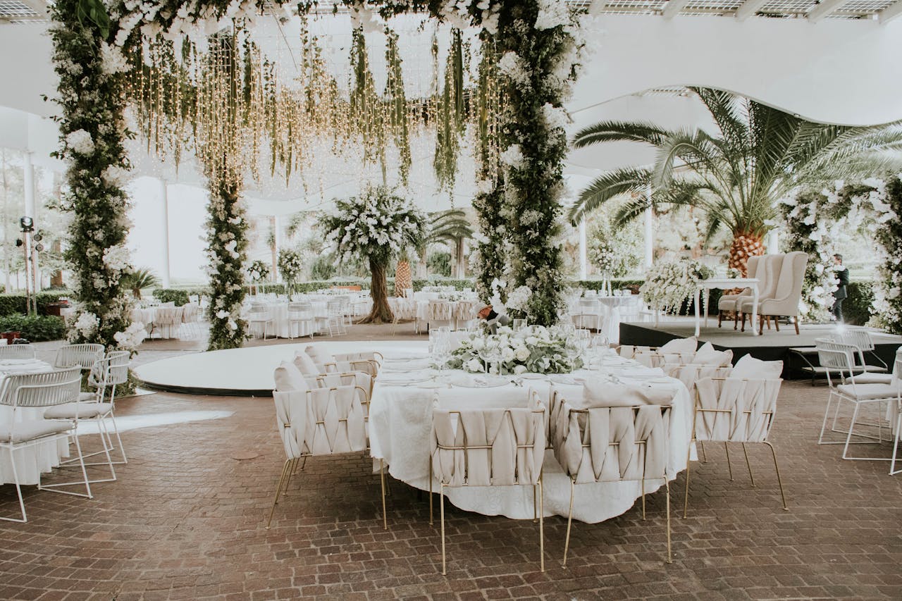 heros-img Stunning outdoor wedding setup featuring floral decorations, elegant seating, and ambient lighting.