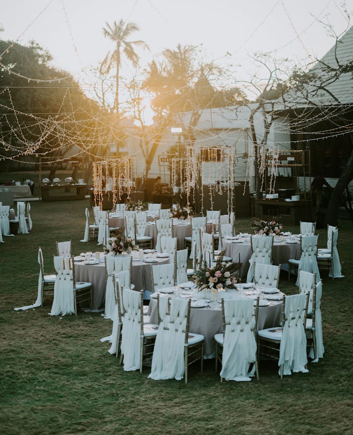 about-us-01 Charming sunset-lit outdoor wedding setup with adorned tables and chairs, perfect for celebrating love.